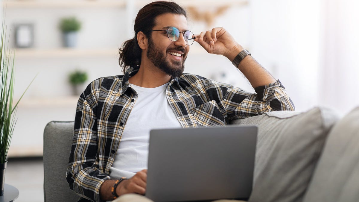 A person sitting on the couch using a laptop.