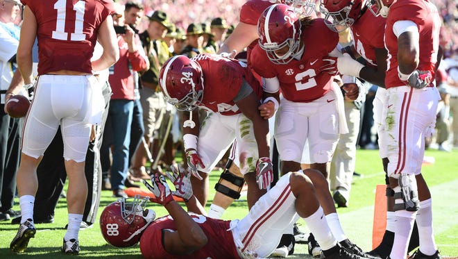 Alabama Crimson Tide teammates come over to check on tight end O.J. Howard (88) after scoring a touchdown against the Texas A&M Aggies during the second quarter at Bryant-Denny Stadium.
