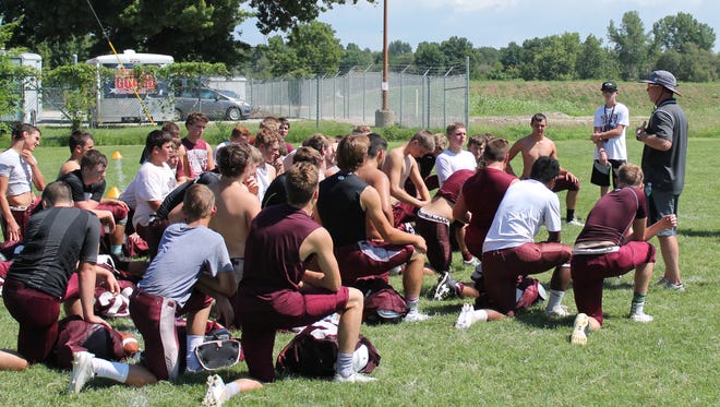 Members of the Strafford High School football team gather at the end of a scrimmage as part of the 2016 Evangel University football team camp.