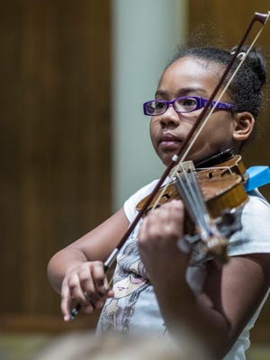 Asiah Williams, 10, of Lansing, thinks it was “pretty great trying it” referring to the violin lesson.