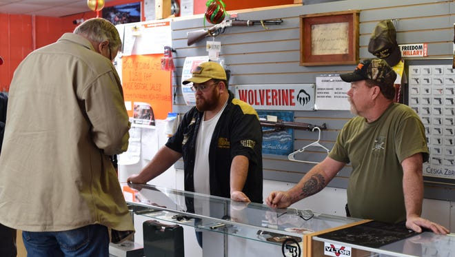 Chaz Hunter, left, and Don Hunter help a customer at Hunter’s Guns, Ammo & Sporting Goods in Yerington on Saturday.