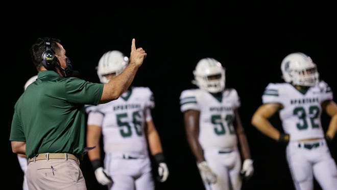 Athens Academy coach Josh Alexander calls out to his team during the first half of a high school football game.