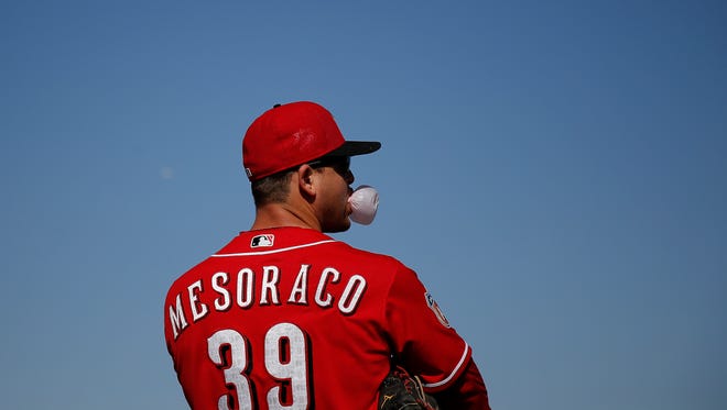 Cincinnati Reds catcher Devin Mesoraco (39) blows a bubble during pop fly drills at Cincinnati Reds spring training, Saturday, Feb. 27, 2016, in Goodyear, Arizona.