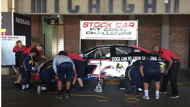 Campers change tires on a stock car in Ann Arbor on Thursday, July 6, 2017. The campers were at the University of Michigan as part of the Youth Impact Program, a nationwide organization that works with teams such as the Wolverines to help educate at-risk, inner-city children.