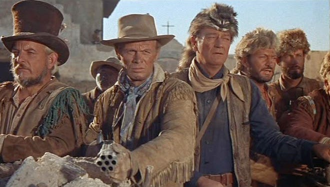 John Wayne (in coonskin cap) played Davy Crockett and Richard Widmark (with multibarreled gun) played Jim Bowie.