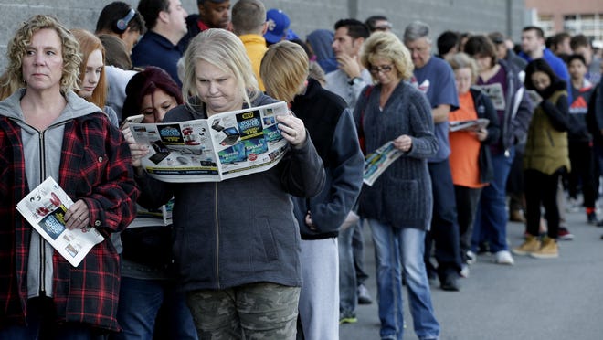 FILE - In this Thursday, Nov. 23, 2017, file photo, people wait in line for a Best Buy store to open for a Black Friday sale on Thanksgiving Day, in Overland Park, Kan. On average, Americans plan to spend more than $550 on gifts for friends and loved ones this holiday season, according to a recent NerdWallet survey conducted by Harris Poll. But budgets are tight. (AP Photo/Charlie Riedel, File)