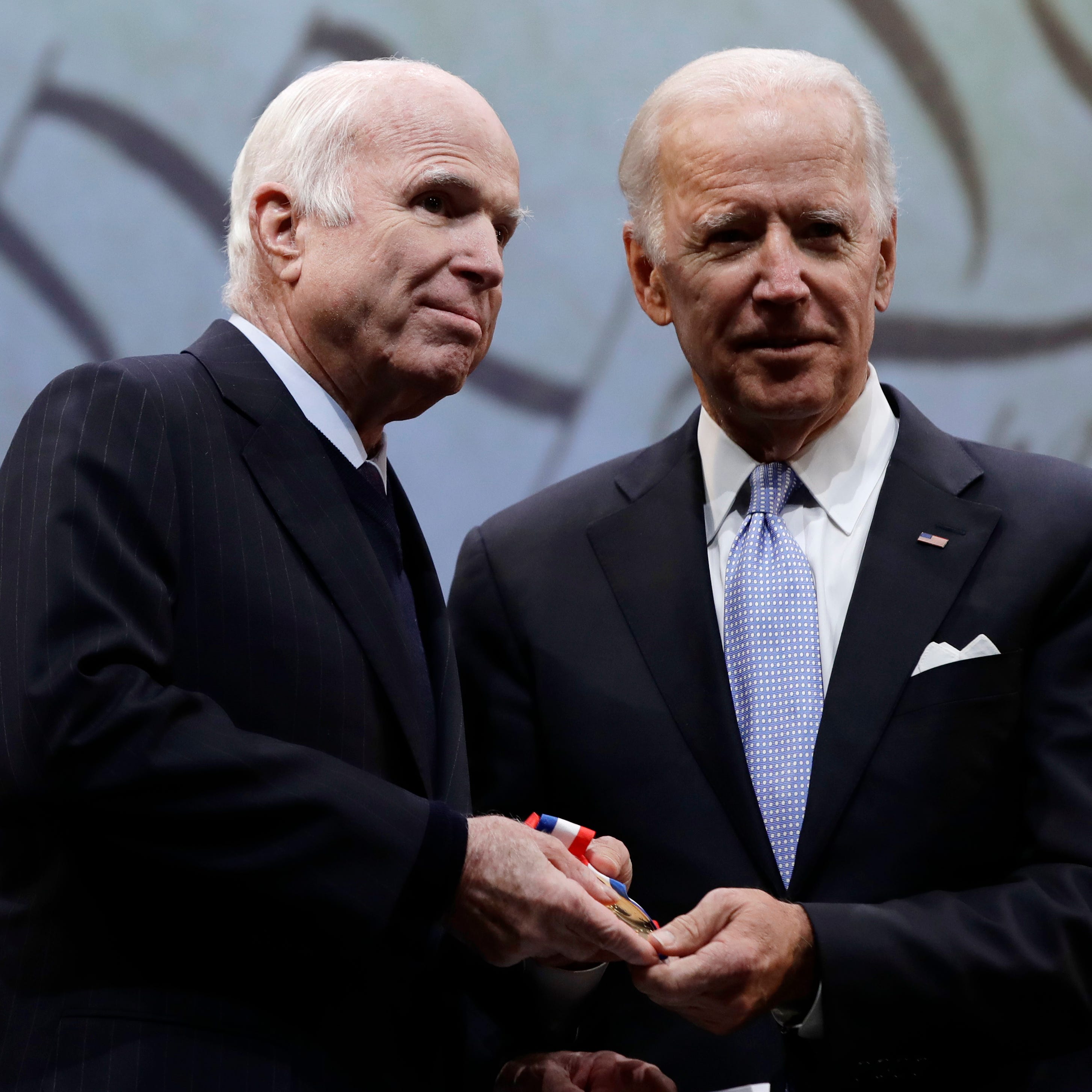 Sen. John McCain, R-Ariz., receives the Liberty Medal from Chair of the National Constitution Center's Board of Trustees, former Vice President Joe Biden, and center President and CEO Jeffrey Rosen in Philadelphia, Monday, Oct. 16, 2017. The honor is