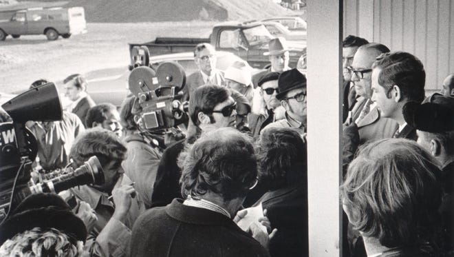Reporters and photographers surround Gov. William Milliken, at right, as he tours the Detroit water tunnel disaster scene in Fort Gratiot in 1971