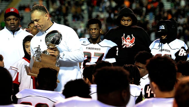 Pearl-Cohn coach Tony Brunetti holds the runnerup trophy during the presentation after the Class 4A BlueCross Bowl on  Dec 5, 2015, in Cookeville. Pearl-Cohn lost to Knoxville Catholic 48-8.