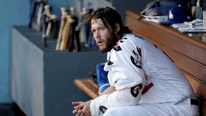 Los Angeles Dodgers starting pitcher Clayton Kershaw sits in the dugout during the first inning of Game 1 of baseball's World Series against the Houston Astros Tuesday, Oct. 24, 2017, in Los Angeles.