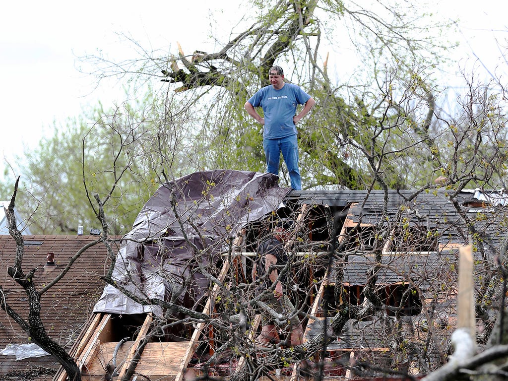 Mickey Opielski, and his brother, Jason work on a duplex roof after severe weather moved through Bexar County, Tx. Severe storms pushed through parts of San Antonio, damaging dozens of homes but causing only minor injuries