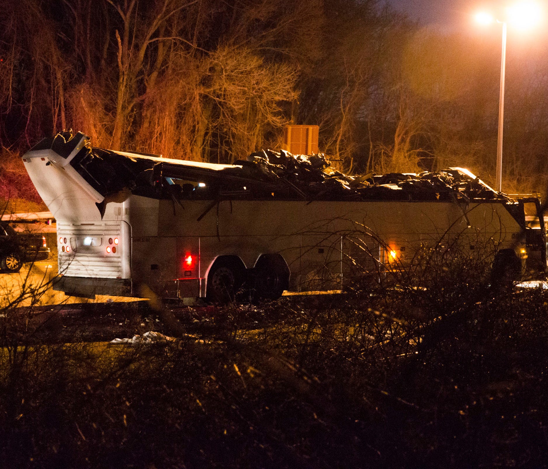 A bus that was carrying teenage passengers sits on the side of the roadway after it hit an overpass on the Southern State Parkway in Lakeview, N.Y., on Sunday.