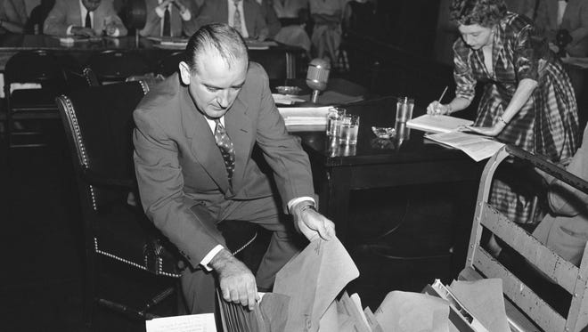 Senator Joseph R. McCarthy (R-Wisc) checks a hand truck load of material he brought with him July 3, 1952 for his appearance before the Senate Rules subcommittee. The subcommittee called McCarthy for testimony on his resolution seeking an investigation of Senator William Benton (D-Conn). The McCarthy resolution accuses Benton of having followed a pro-communist line while he was assistant secretary of state in 1945-47.