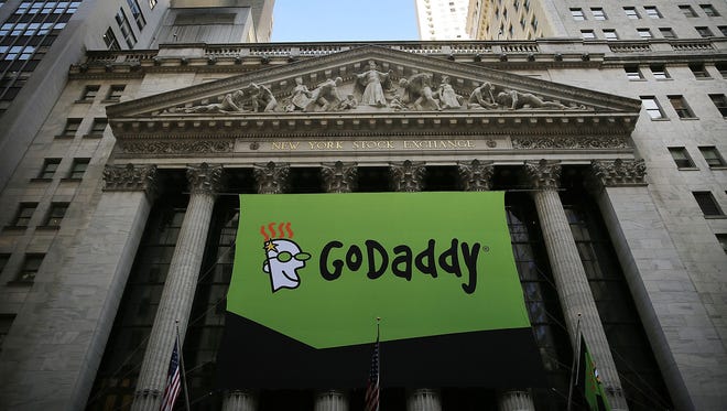 The GoDaddy banner hangs outside of the New York Stock Exchange as the website hosting service makes its initial public offering April 1, 2015, in New York City. On Sunday, Aug. 13, 2017, the company announced it would no longer provide service to the neo-Nazi website, "The Daily Stormer."