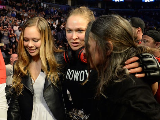Rousey celebrates with her mom and sister after defeating
