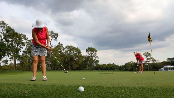 Florine Mason, 69, left, putts as her friend Elaine Sterner, 76, lines up a putt as they practice along the Copperhead course at Innisbrook Golf Resort, Monday, March 16, 2020, in Palm Harbor, Fla. With the Valspar Tournament shut down due to the coronavirus outbreak, golfers had the unique opportunity to play on a tour-ready golf course.