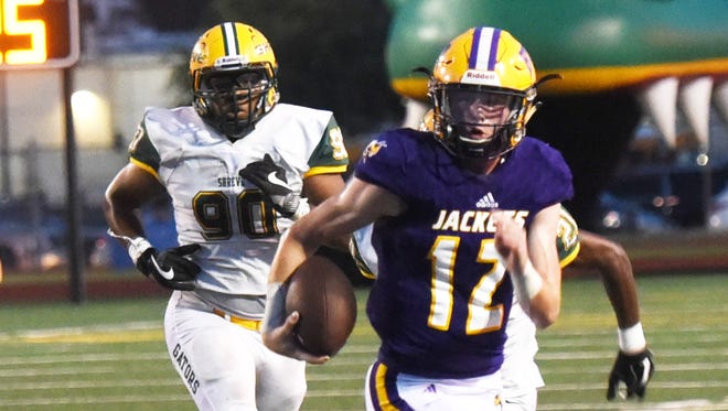 Byrd quarterback Carson Dunn runs away from Captain Shreve defenders during the Yellow Jacket's 34-17 win Thursday at Lee Hedges Stadium.