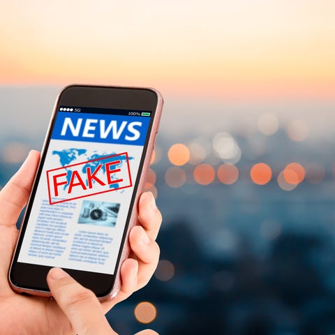 A news story on a smartphone with the word fake in