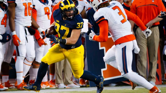 Michigan's Bobby Henderson carries the ball in the second half against  Illinois.