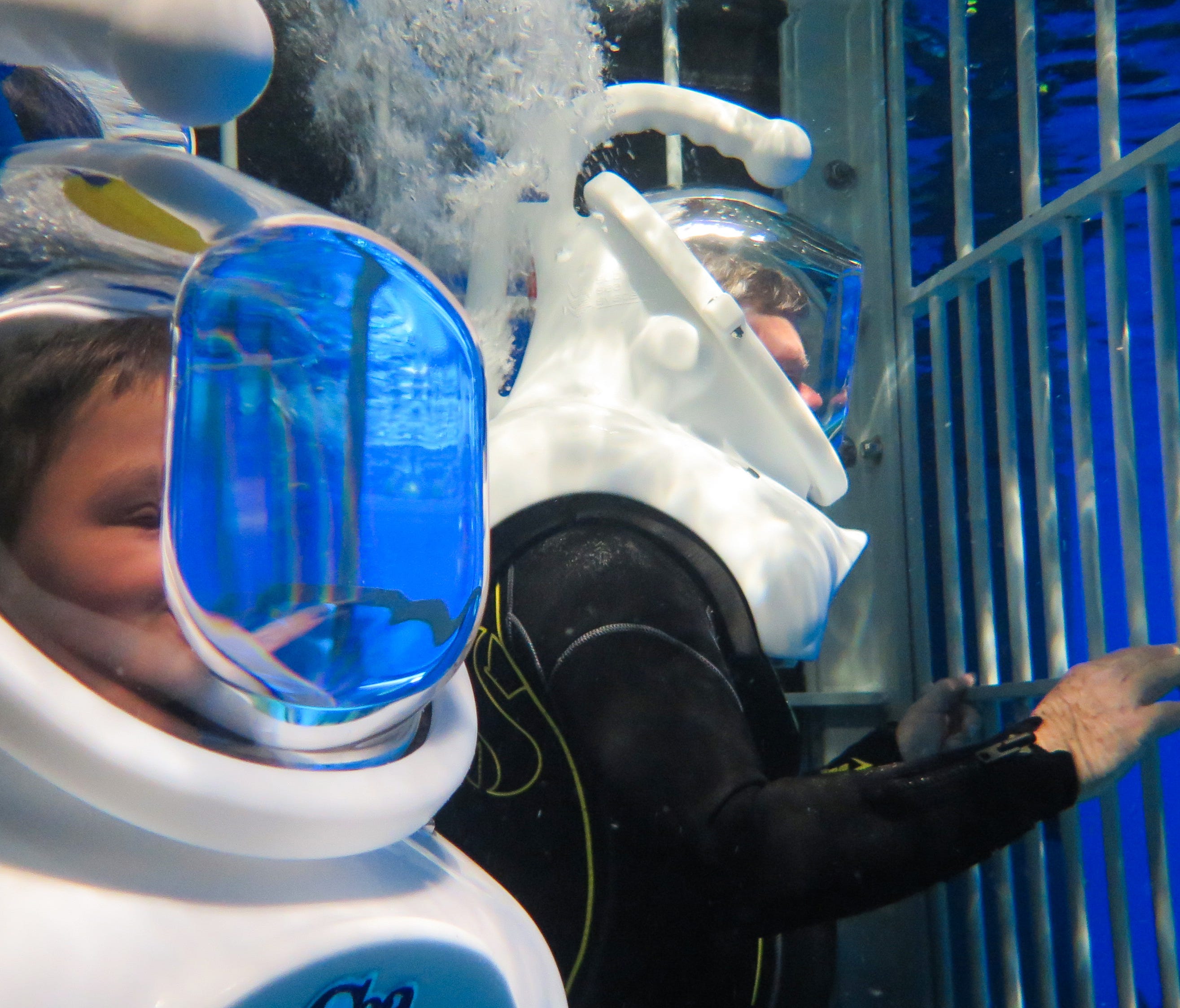News-Leader reporter Wes Johnson (right) tries out Wonders of Wildlife's newest attraction, the Out To Sea Shark Dive, where visitors don wetsuits, diving helmets and climb inside a shark cage that takes you into the aquarium's shark tank.