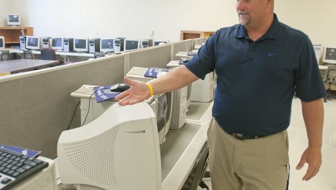 Yale Superintendent Ken Nicholl shows computers that were running Windows 95 in 2013 and couldn't be updated in one of the computer labs in the middle school.