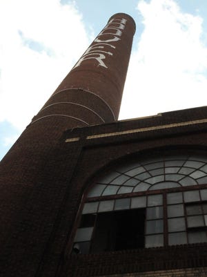 The famous Hoover smokestack is shown in this file photo. TRANZACT, which is housed in the Hoover complex, is hiring insurance agents.