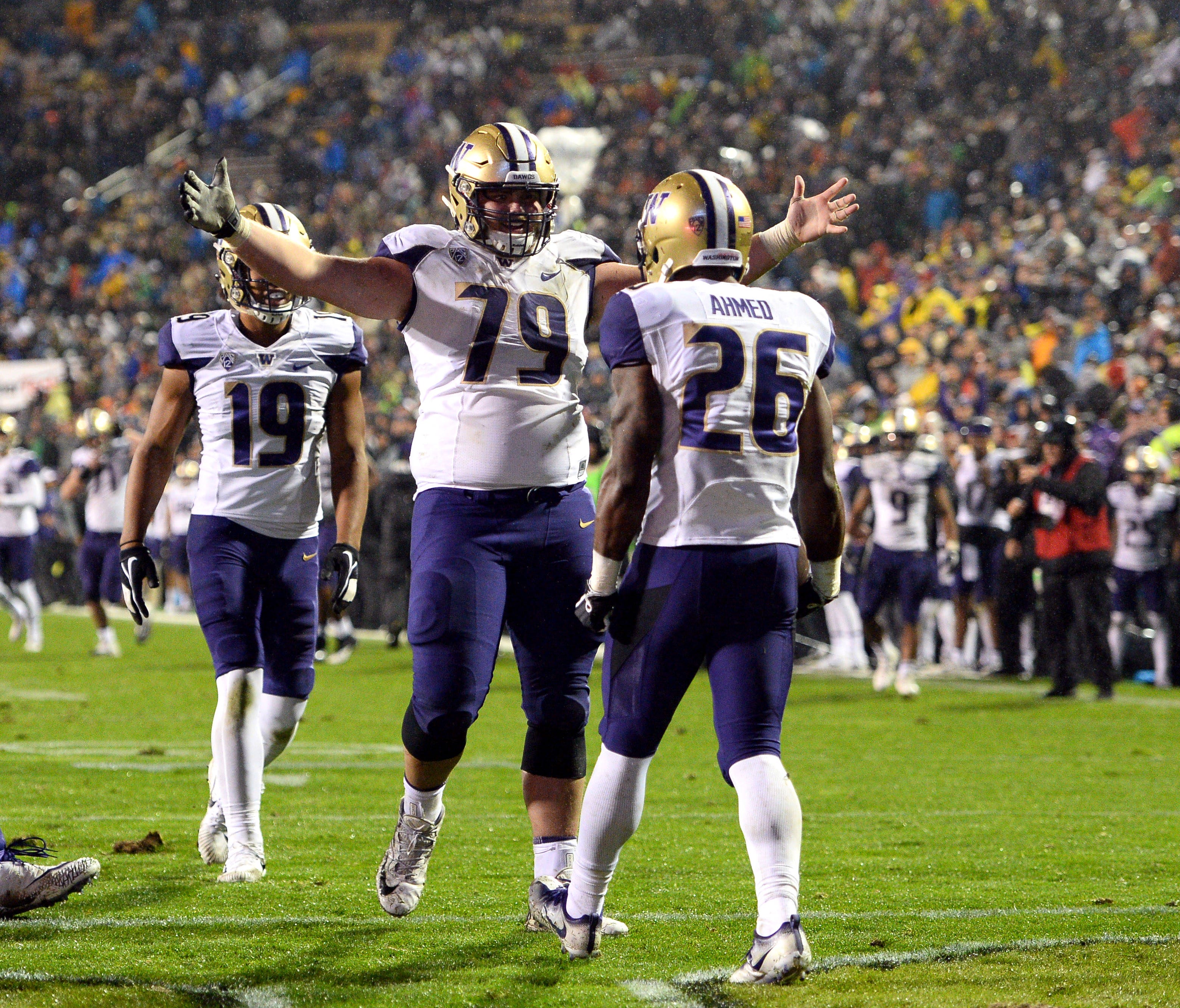 Washington running back Salvon Ahmed (26) celebrates his touchdown run with teammates during the second half against Colorado.