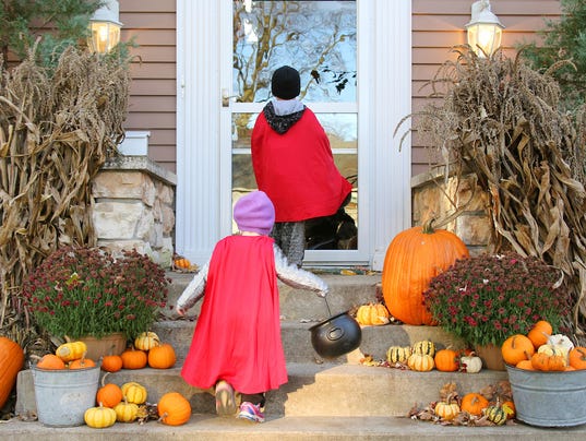 Children in Cape Costumes Trick-or-Treating on Halloween