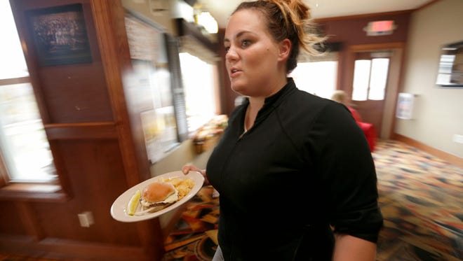 Army veteran Susie Fortman delivers a meal during a lunch rush at Sheryl's Club 175 in Slinger  where she works.