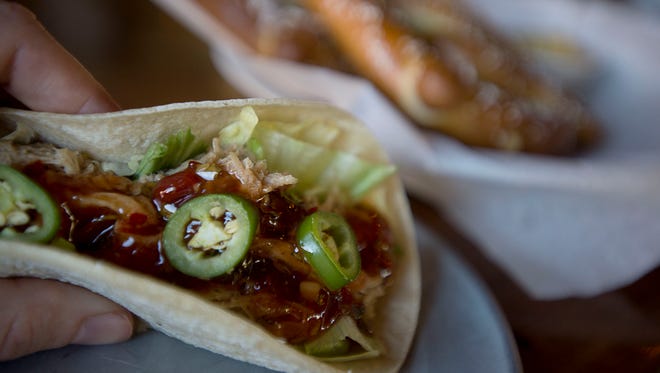 A Thai pulled pork taco and the pretzels with mustard are among a few of the pub food favorites at the Thirsty Monk in Biltmore Park.
