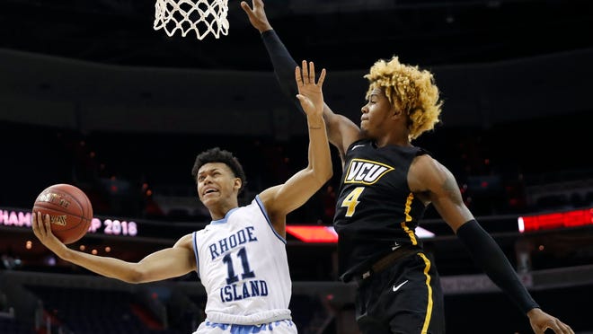 Rhode Island guard Jeff Dowtin (11) attempts a shot as VCU forward Justin Tillman (4) defends during the first half of an NCAA college basketball game in the Atlantic 10 Conference tournament, Friday, March 9, 2018, in Washington.  (AP Photo / Alex Brandon)