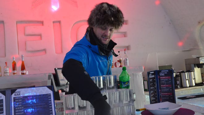 At Hotel de Glace in Quebec City, Canada, a bartender mixes drinks in glasses made of ice.