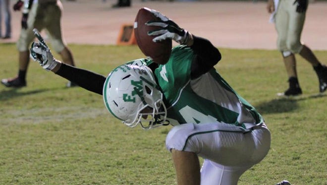 Fort Myers High school football player Sam Turner kneels in prayer after a touchdown Friday, honoring God and paying tribute to slain teammate Jo Jo Brunson who was honored in a pre-game ceremony.