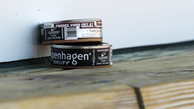 Cans of smokeless tobacco sit in the Tampa Bay Rays dugout before a baseball game.