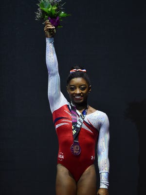 U.S. gymnast Simone Biles celebrates with her bronze medal on the podium following the women's vault final.