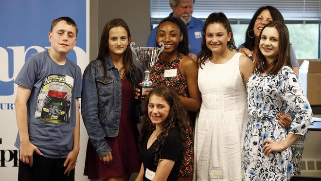 Students from St. Leo the Great hold their school trophy as the video winner during the Student Voices ceremonies at the Press in Neptune Wednesday evening.
