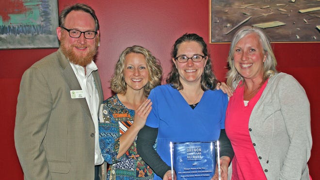 Gubser Neighborhood received the 2017 Hunger Buster of the Year Award from the Oregon Food Bank Network for its work in the Keizer Miracle of Christmas. Pictured, from left, Rick Gaupo, President of Marion-Polk Food Share, and Jessica Ratliff, Brigette Eisele and Jennifer Skipper of the Gubser Neighborhood.