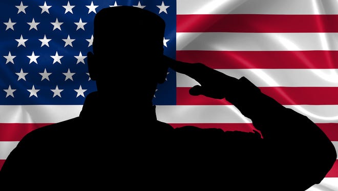 Silhouette of American soldier saluting to the U.S. flag.