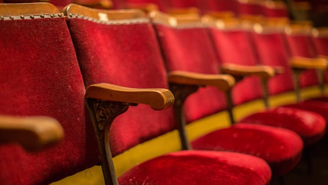 Old fashion cinema theatre seats with wooden arms and flip-up seats