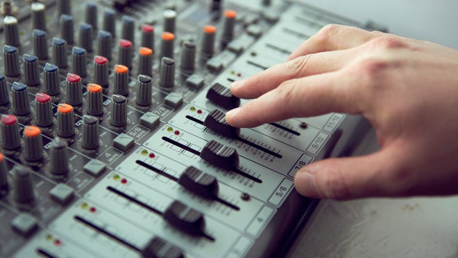 An expert adjusting audio mixing console.