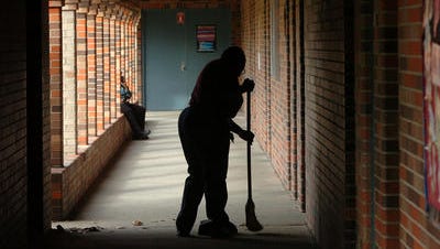 A custodian sweeps a hallway at Acadian Middle. Custodians were among several support personnel honored by the school board Wednesday night.