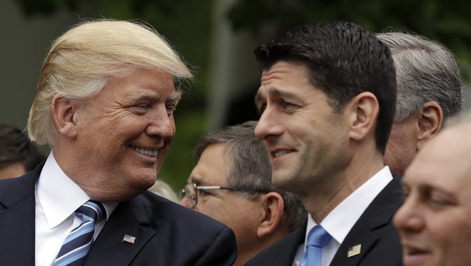 President Donald Trump talks to House Speaker Paul Ryan of Wisconsin in the Rose Garden of the White House in Washington Thursday after the House pushed through a health care bill.