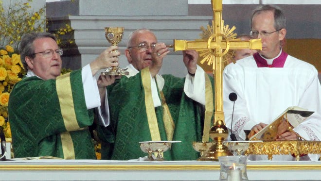 Pope Francis, center, and others prepare Holy Communion during a large outdoor Mass Sunday in Philadelphia. 