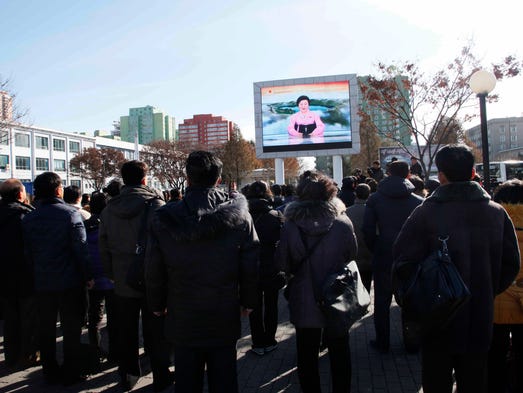 People watch the news broadcast announcing North Korean