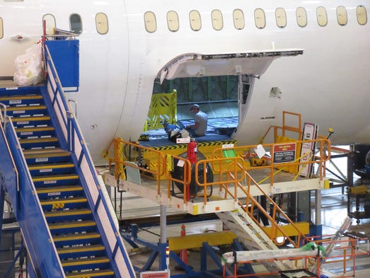 A Boeing employee works on a Dreamliner as it makes