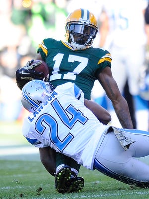 Davante Adams is dragged down by the Lions' Nevin Lawson after a reception in the first quarter.
