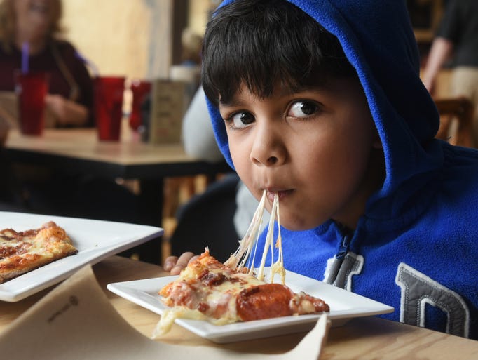 Ayan Dey of Birmingham eats a cheesy pepperoni pizza