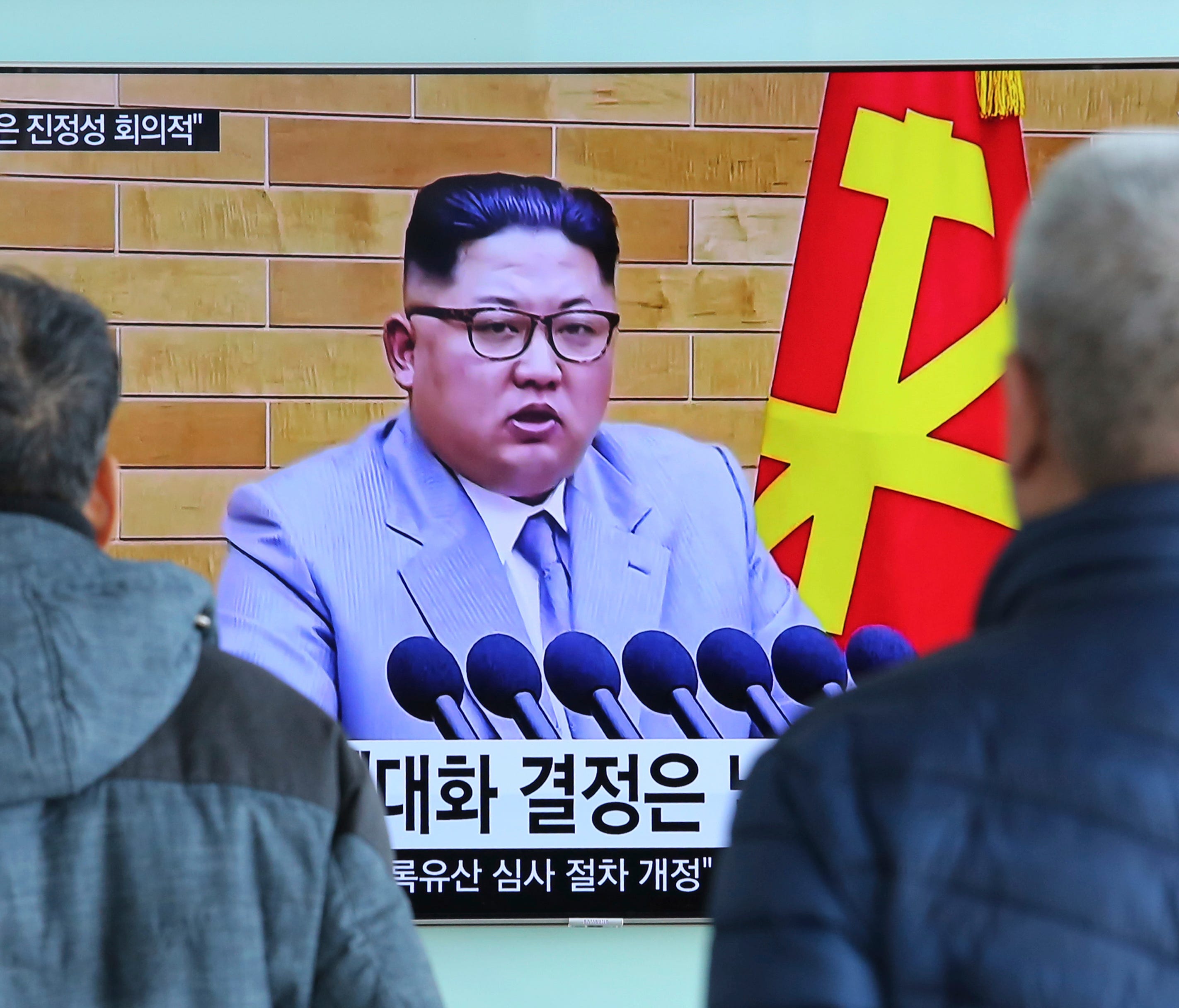 People watch a TV screen showing North Korean leader Kim Jong Un's New Year's speech.