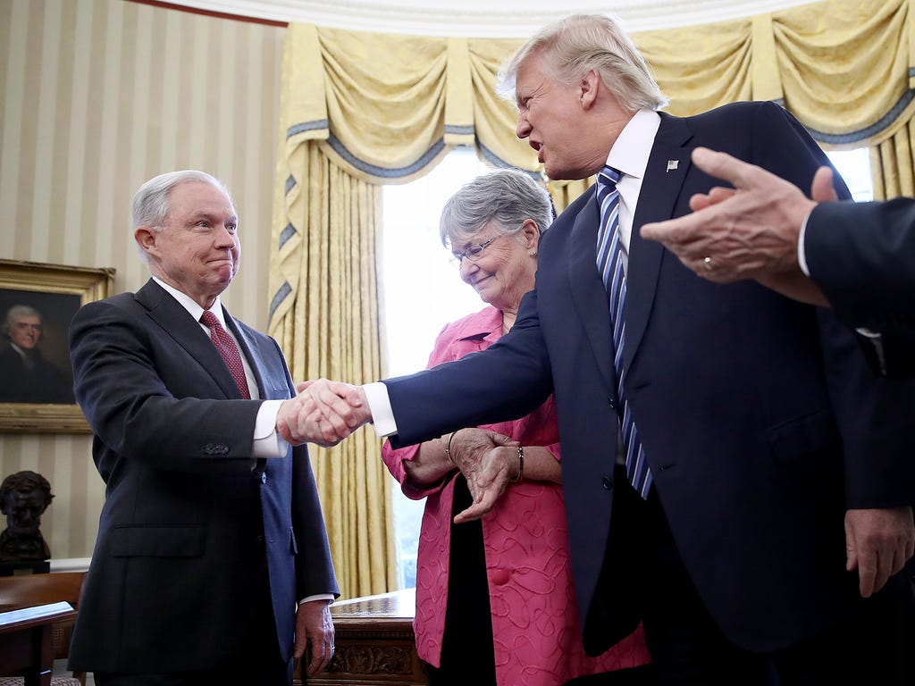 President Donald Trump shakes the hand of  Jeff Sessions after Sessions was sworn in as the new U.S. Attorney General by U.S. Vice President Mike Pence in the Oval Office of the White House in Washington.