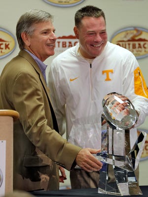 Tennessee head coach Butch Jones, right, smiles as he receives the trophy from Outback Steakhouse president Jeff Smith after Tennessee defeated Northwestern 45-6 in the Outback Bowl NCAA college football game Friday, Jan. 1, 2016, in Tampa, Fla. (AP Photo/Chris O'Meara) 